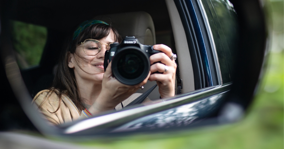 Girl holding camera in mirror